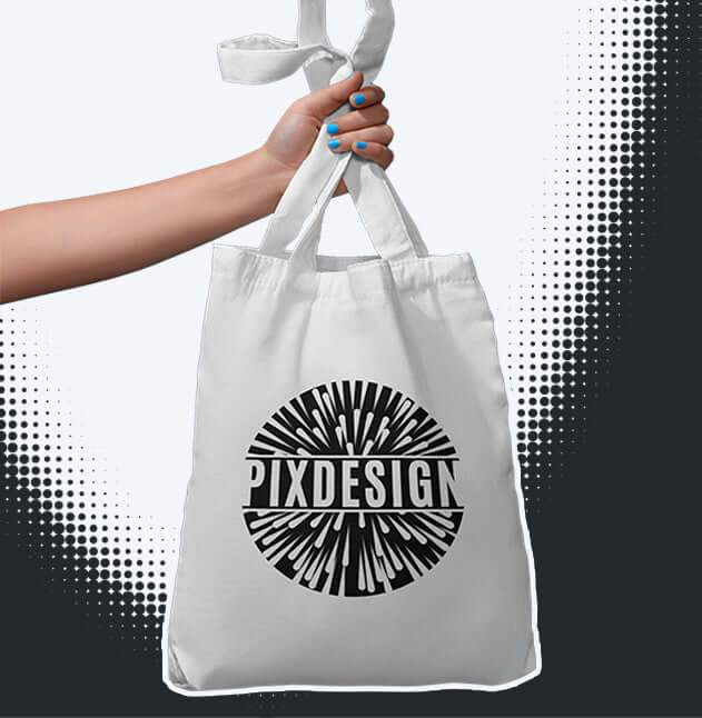 Person hält eine weiße Tragetasche mit dem auffälligen PIXDESIGN-Logo. Optisch ansprechend und umweltfreundlich.